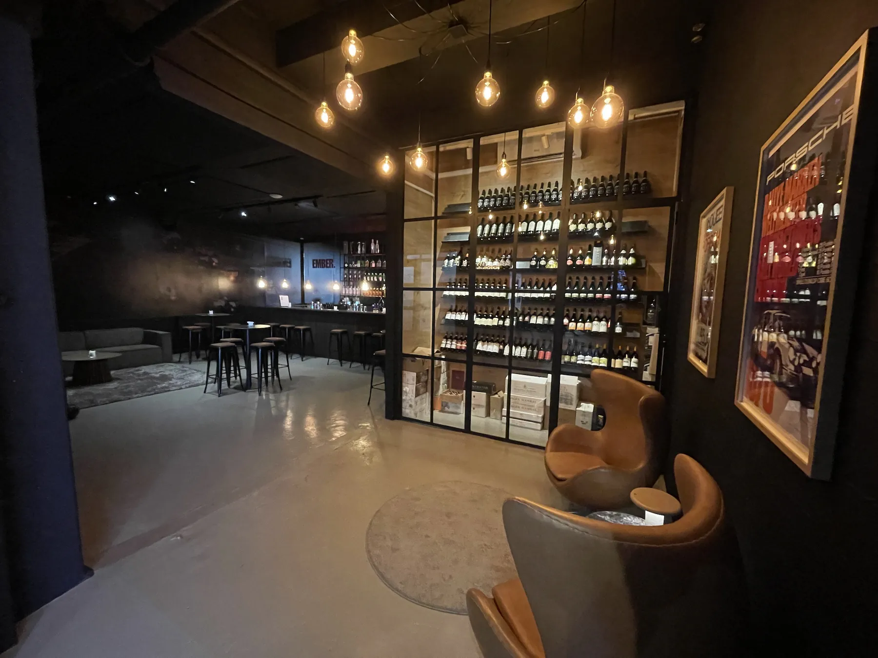 Oplyst vinvæg og loungestole i EMBERs bar på Adelgade 11
